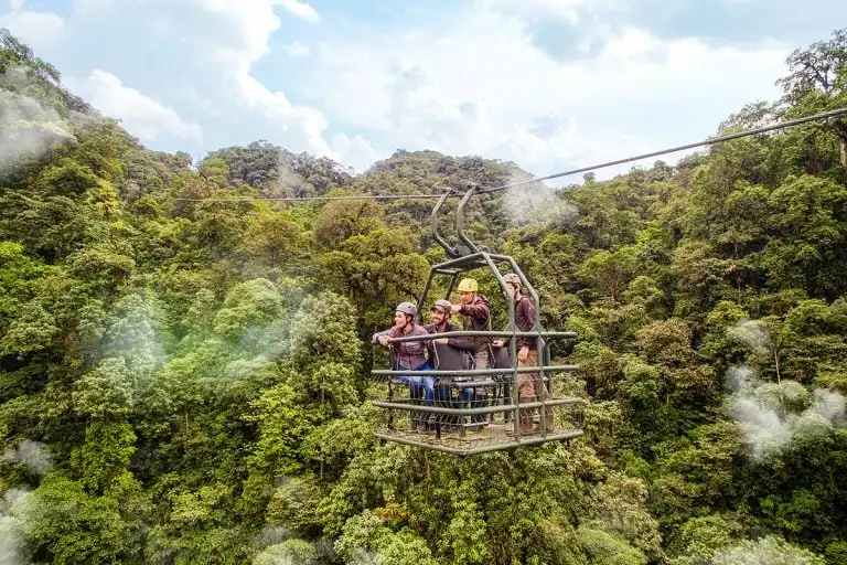Guests on the Dragonfly aerial tram at Mashpi Lodge Reserve, Ecuador, exploring the lush rainforest.