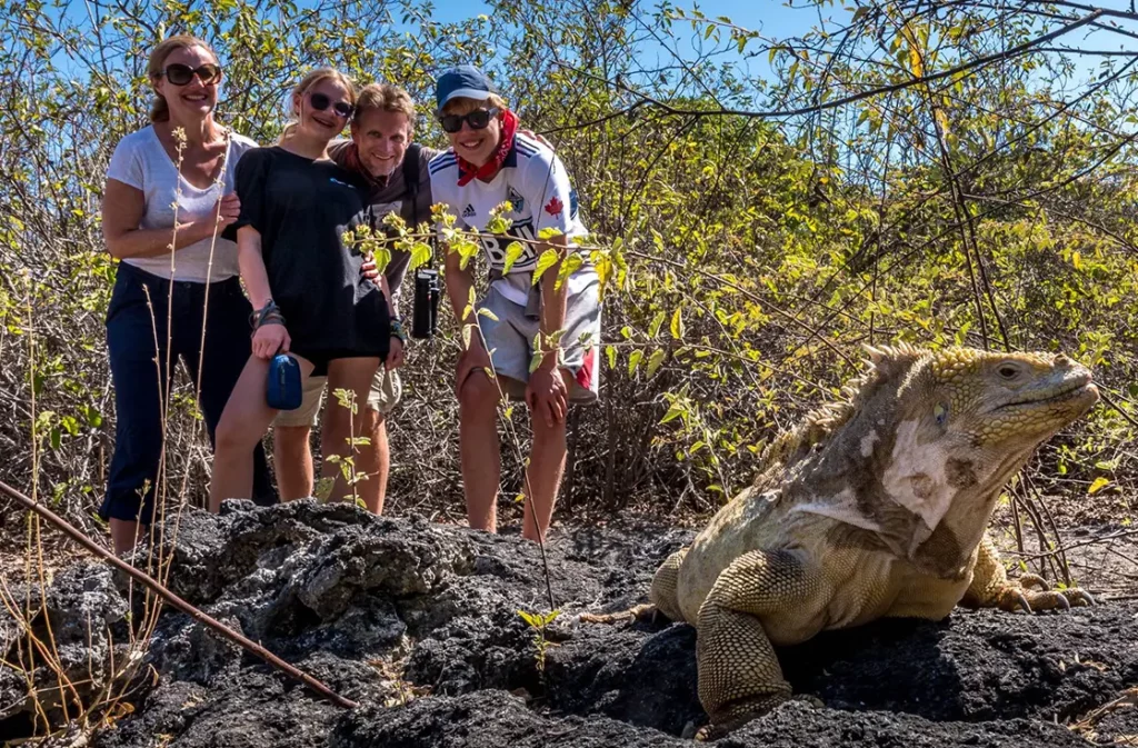 Guests alongside a land iguana on the uplifted shoreline of Urbina Bay, Isabela Island